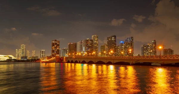 Miami, Florida városképe a Biscayne-öbölben. Panoráma alkonyatkor városi felhőkarcolók és híd a tenger felett elmélkedve. — Stock Fotó