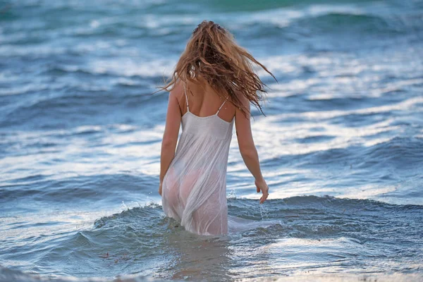 年轻性感女人在海上与性感透明的夏装。夏天的海滩，性感女孩的身体。热带海滩度假时穿着白色衣服的女孩. — 图库照片