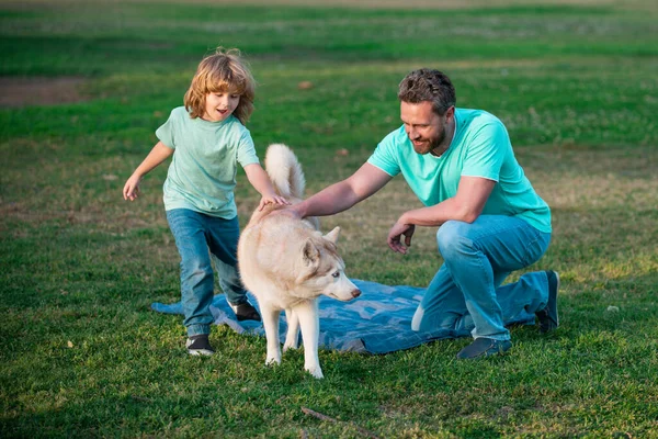 Père et fils marchant avec chien sur la nature, à l'extérieur. Bonne famille. Papa et enfant avec animal de compagnie. — Photo