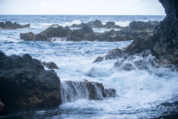 Spruzzando onde sulla roccia nel mare. Onda ha colpito la pietra nell'oceano con uno sfondo d'acqua. — Foto Stock