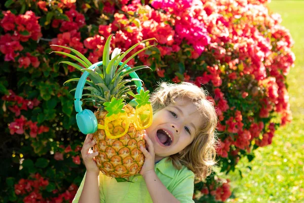 Child boy holding pineapple smiling with happy face. Summer fruits. — Stock Photo, Image
