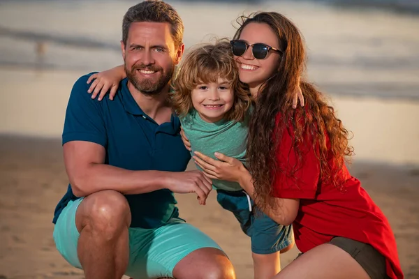 Счастливая семья обнимается на пляже. Отец и дети играют на пляже. Концепция дружественной семьи. — стоковое фото