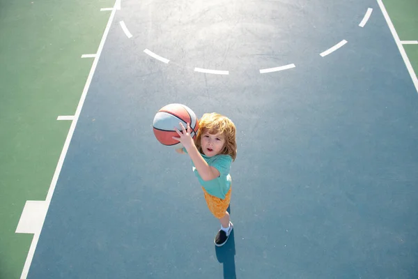 Crianças jogando basquete, ao ar livre no playground. Actividades desportivas infantis. Kid homem de esportes. — Fotografia de Stock