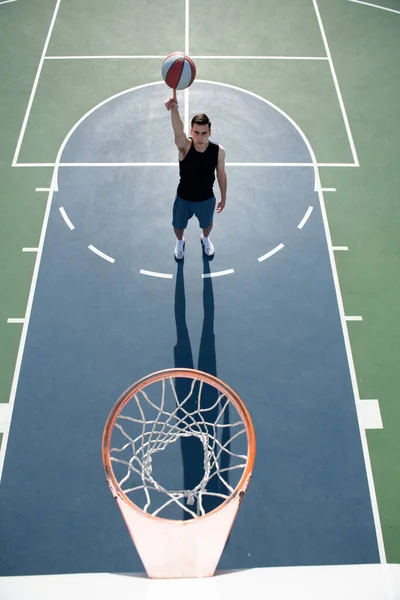 Basketbalspeler schietbal in hoepel buitenbaan. Stedelijk jeugdspel. Begrip sportief succes, punten scoren en winnen. — Stockfoto