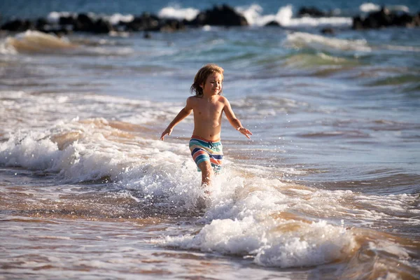 Niño saltando en olas marinas. Saltar por el agua salpicaduras de mar. Vacaciones de verano para niños. — Foto de Stock