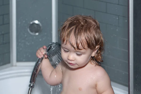 Un niño en una bañera. Pequeño bebé está lavando su cabello en el baño. —  Fotos de Stock