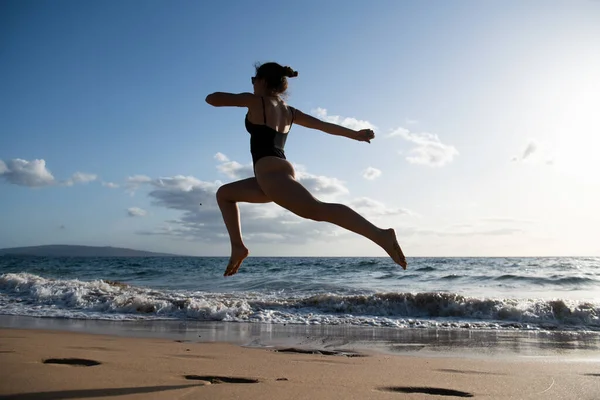 シルエットを動かす女。健康フィットネス女の子ジョギングでビーチ. — ストック写真