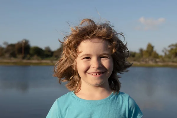 Porträt eines fröhlich lachenden Kindes im Freien. Positive Kindergesichter aus der Nähe. — Stockfoto