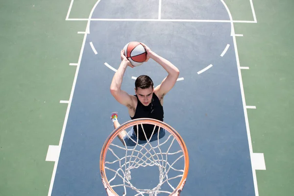 Koszykarz. Sport i koszykówka. Człowiek skacze i rzuca piłkę do kosza. — Zdjęcie stockowe