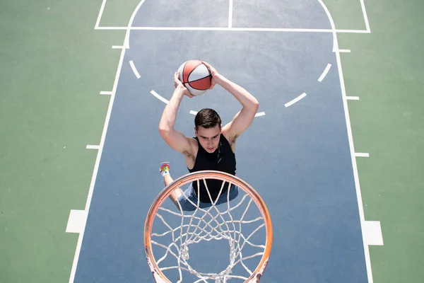 Jogador de basquetebol. Desporto e basquetebol. Homem pula e joga uma bola na cesta. — Fotografia de Stock