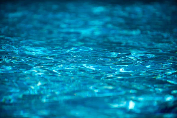 Sfondo d'acqua. Acqua blu, increspature e riflessi. Texture della superficie dell'acqua e del fondo piastrellato. — Foto Stock