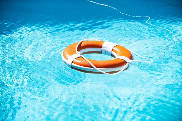 Rettungsring im Schwimmbad. Sommerferienkonzept. Rettungsboje im Wasser. Hilfekonzept. — Stockfoto