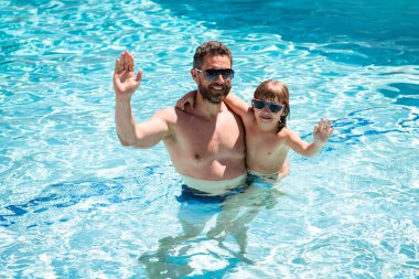 Baba oğul havuzda yüzüyor, yaz ailesi. Havuz partisi. Babası yüzme havuzunda oynayan bir çocuk. Yaz tatili. Aquapark. Baba oğul boş vakit..