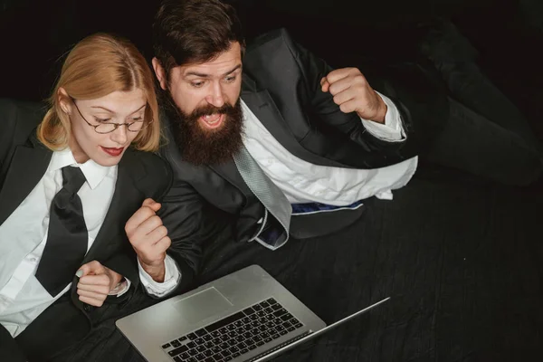 Retrato de dos personas de negocios emocionadas mirando la pantalla de un portátil. Los hackers usan computadoras portátiles. Hackers hackeando en la oscuridad. —  Fotos de Stock
