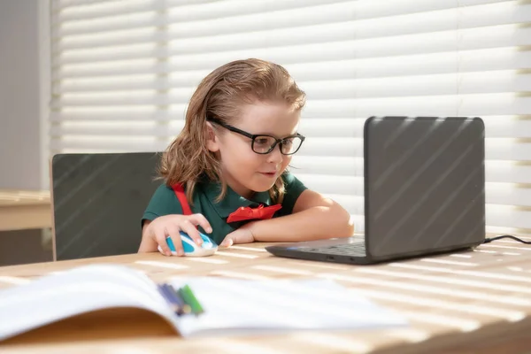 Smart school jongen die huiswerk schrijft met behulp van notebook computer om te studeren. Kleine student, schooljongen leren online. — Stockfoto