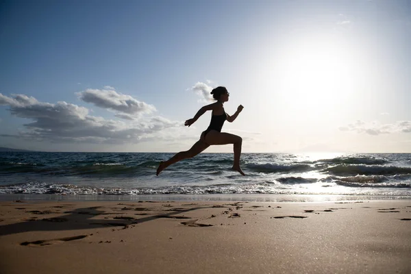 海岸を走っている女性。美しいです若いです女の子でスポーツウェアで海で実行. — ストック写真