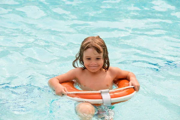 Zomervakantie. Jongen heeft plezier in het aquapark. Gelukkige jongen die met een reddingsboei speelt. Zomervakantie. — Stockfoto