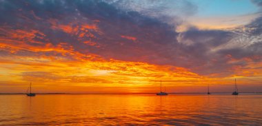 Denizin üzerinde deniz manzaralı altın gün doğumu. Doğa manzarası. Okyanus batımında güzel turuncu ve sarı renk. Altın gökyüzü ve bulutlu deniz manzarası.