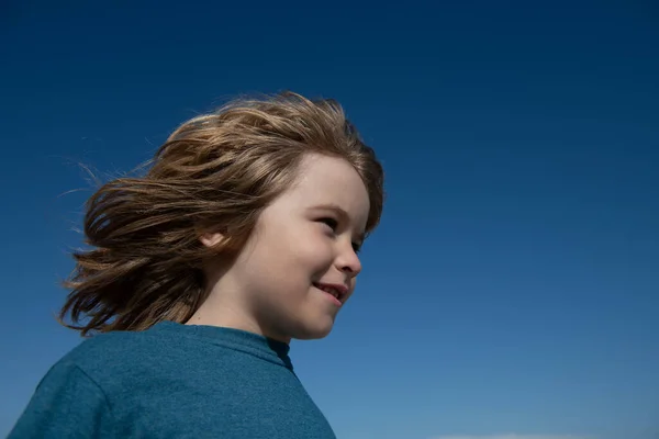 Ritratto di bambino su cielo blu con spazio per la copia. Concetto di bambini che distolgono lo sguardo da un primo piano. Testa sparare bambini ritratto. — Foto Stock