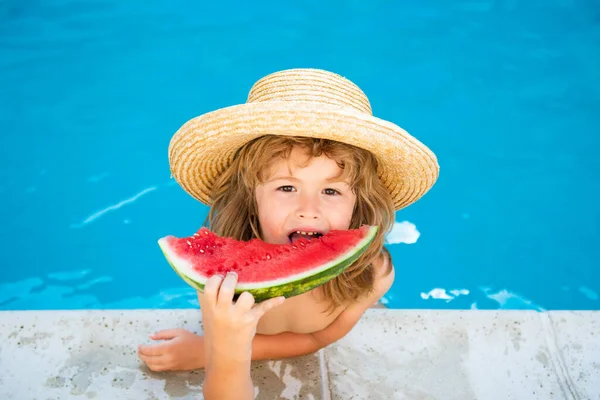 Niño con sandía sonriendo nadando en la piscina en verano en el complejo. Niños con trozo de sandía al aire libre. Vacaciones de verano y concepto de alimentación saludable. — Foto de Stock