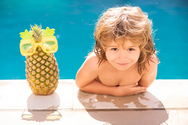 Menino elegante feliz goza de vida na piscina de verão. Abacaxi de verão. — Fotografia de Stock