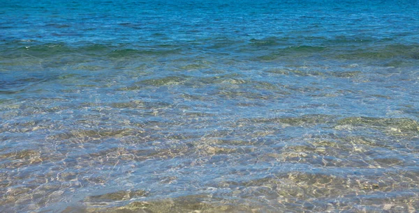用浪花和浪花平静海水表面的纹理.摘要自然背景。水生水面的背景. — 图库照片