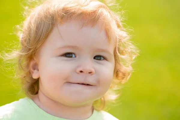 Feche o retrato de um bebê loiro. Engraçado crianças rosto no verão parque da natureza. — Fotografia de Stock