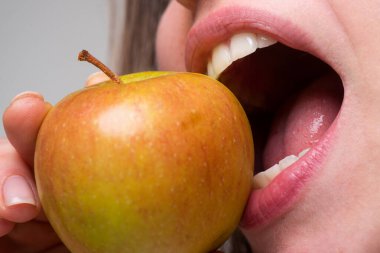 Elmalı sağlıklı beslenme ve sağlıklı dişler yiyen bir kadın. Elma ısırmak. Ağzını kapat..