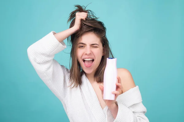 Meisje dat haar conditioner aanbrengt. Een vrouw die haar haar aanraakt. Vrouw houden fles shampoo en conditioner. — Stockfoto