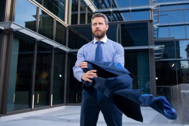 Şehirde duran iş adamı işinde başarılı olduğu için mutlu. İşadamı kazandı..