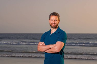 Sahildeki bir adamın portresi. Açık hava yaşam tarzı yakışıklı adam. Sahildeki muhteşem manzara..