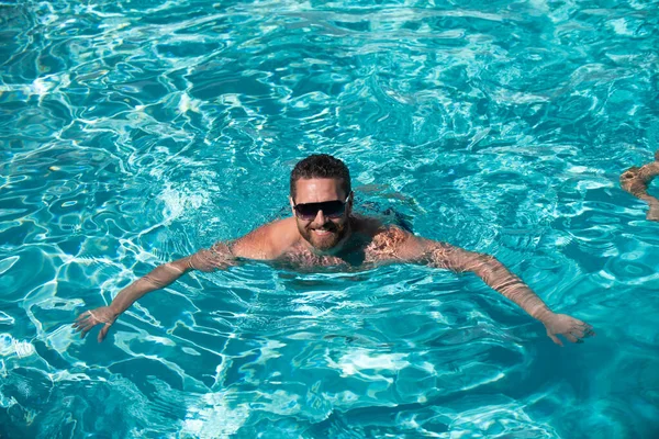 夏季游泳池度假胜地。男人在暑假。戴太阳镜的家伙在游泳池里放松. — 图库照片