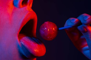 Pembe dudakları olan, lolipop tutan seksi bir kadın ağzı, güzellik kapanışı. Seksi kız lolipopu yaladı. Güzellik konsepti, yakın plan..