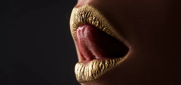 Gold lips. Woman wouth close up with golden color lipstick on lip. Glitter glossy lips biting.