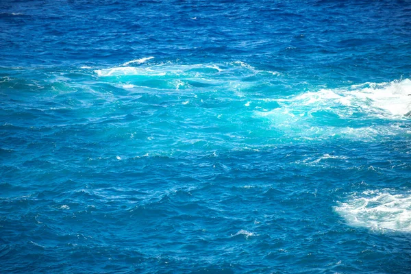 Fondo marino de verano. Textura de la superficie del agua. Patrón de ondulación de agua azul brillante. — Foto de Stock