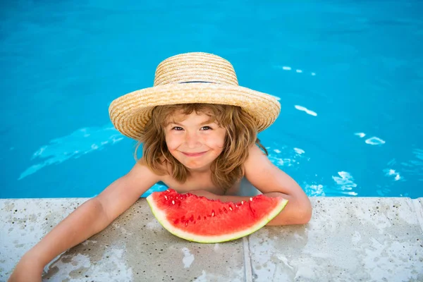 Lindo niño en la piscina comiendo sandía. Disfruta comiendo frutas tropicales. Concepto de niños de verano. Feliz infancia.. — Foto de Stock