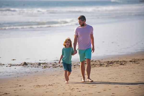 Pai e filho caminhando na praia de verão. Conceito de infância e paternidade. — Fotografia de Stock