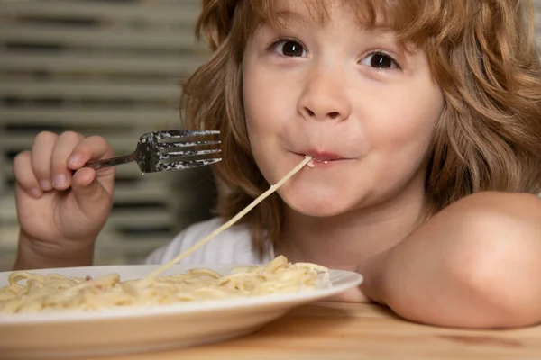 Makarna ve spagetti yiyen sevimli bir çocuğun portresi. Kafkas çocuk yüzünü kapatın. Komik çocuğun yakın plan kafası.. — Stok fotoğraf
