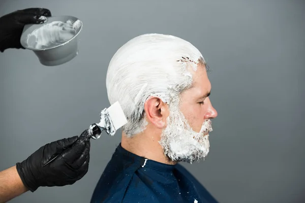 Retrato de cabelo barbudo homem cor. Processo de um homem coloração de cabelo no salão de cabeleireiro. — Fotografia de Stock