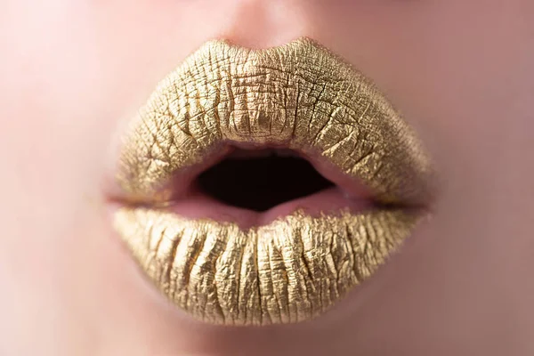 Los labios dorados. Boca de mujer cerca con lápiz labial de color dorado en el labio. Labios brillantes que muerden. — Foto de Stock