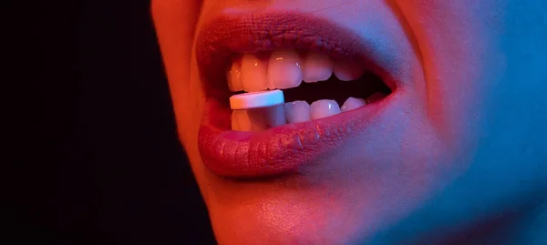 Primer plano de la píldora en dientes de mujer. Lips tiene pastillas en la boca. Primer plano de la mujer enferma que toma la píldora para aliviar el concepto de dolor, suplementos diarios o antidepresivo antibiótico en la boca. — Foto de Stock