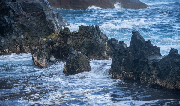 Mořské pozadí. Oceánská vlna naráží na skalnaté pobřeží se sprejem a pěnou před bouří. — Stock fotografie
