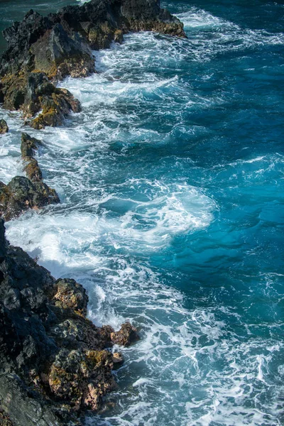Vista de la playa de mar con olas y costa rocosa. Playa de arena roja, Maui en hawaiano. — Foto de Stock