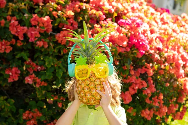 Милый ребенок с ананасом в тропическом саду. Свежие тропические фрукты для детей. Здоровый образ жизни со свежими органическими фруктами. — стоковое фото