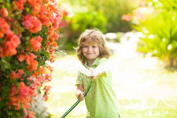 Kids play with water garden hose in yard. Outdoor children summer fun. Little boy playing with water hose in backyard. Party game for children. Healthy activity for hot sunny day. — Stock Photo, Image