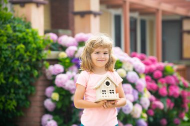Oyuncak ev, aile evi. Gayrimenkul konutları, evde bakım, aile gündüz bakımı konsepti. Mutlu çocuk yeni bir ev hayal ediyor..