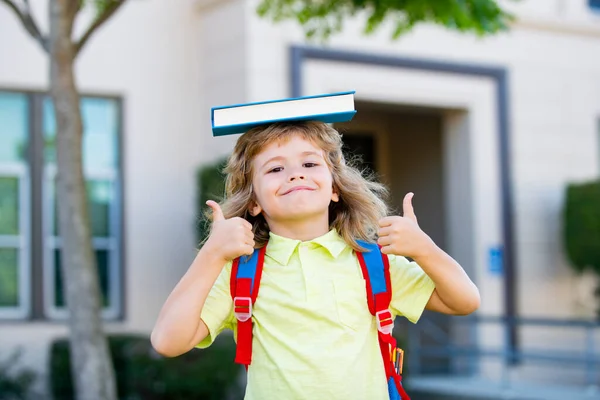 Lustig kille redo för skolan. Skolpojke elev med ryggsäck utomhus med tummen upp. — Stockfoto