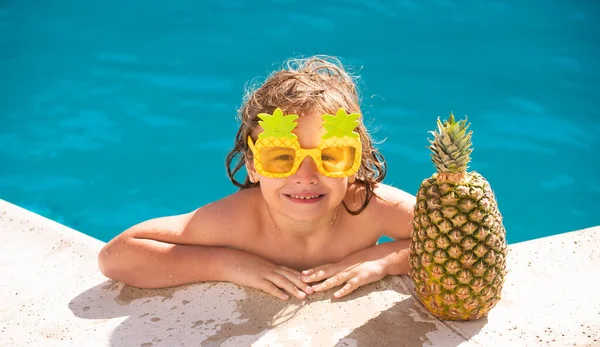 Sana attività all'aperto per bambini. Vacanze estive e concetto di vacanza per bambini. Ragazzino che si diverte in piscina. Frutta dell'ananas estiva. — Foto Stock