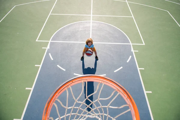 Angle view from on top of child playing basketball on playground. — Stock Photo, Image