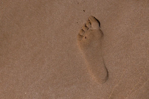 Pas de pieds rapprochés sur la plage de sable fin. — Photo